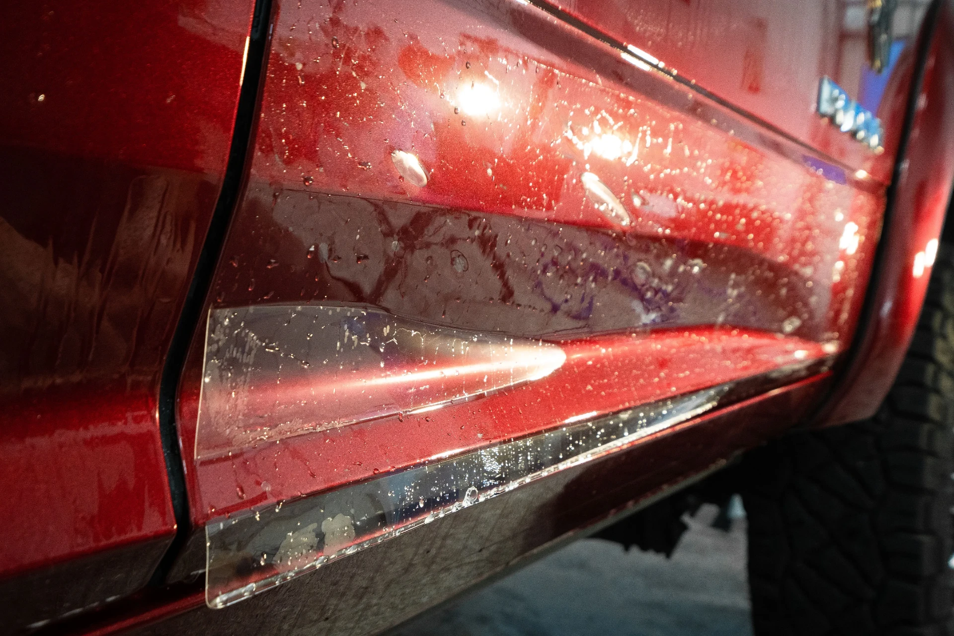 Clear paint protection film applied along a red vehicle body line